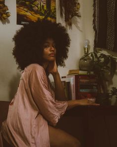 a woman with an afro sitting on a couch