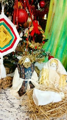 a nativity scene is displayed in front of a christmas tree with ornaments and decorations