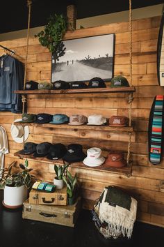 a room with wooden walls and shelves filled with hats, sweaters and other items