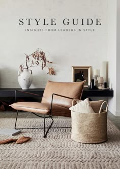 a living room with a chair, rug and potted plant on the floor in front of a white wall