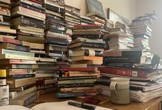 a stack of books sitting on top of a wooden table