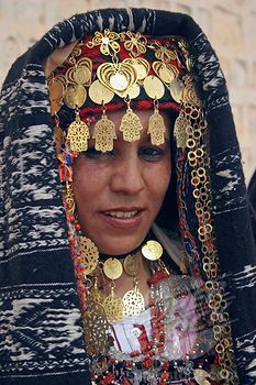 a woman wearing an elaborate headdress and jewelry