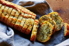 sliced bread with pesto on it sitting on top of a cloth