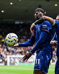 two soccer players are hugging each other while holding a ball in front of their faces