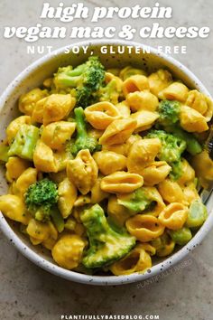 a white bowl filled with pasta and broccoli on top of a marble counter