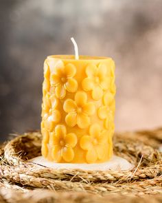 a yellow candle sitting on top of a pile of hay