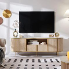 a flat screen tv sitting on top of a wooden cabinet in front of a white wall