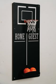 a basketball hoop mounted to the side of a wall next to two orange balls in front of it