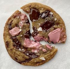 a chocolate chip cookie with pink icing and sea salt on it's side