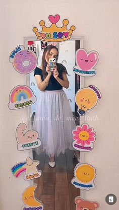 a woman taking a selfie in front of a mirror with lots of stickers on it