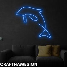 a living room with a couch and a dolphin neon sign on the wall above it