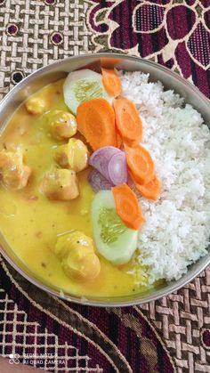 a bowl filled with rice and vegetables on top of a table