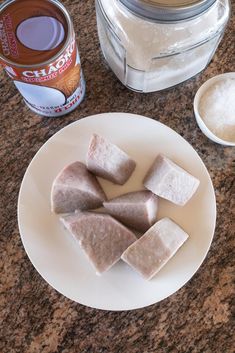 several pieces of food on a white plate next to a can of cocoa and sugar