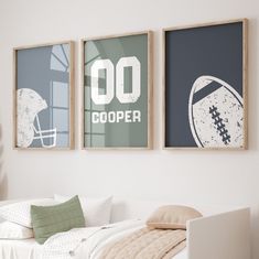 two framed football posters hang on the wall above a bed in a room with white walls