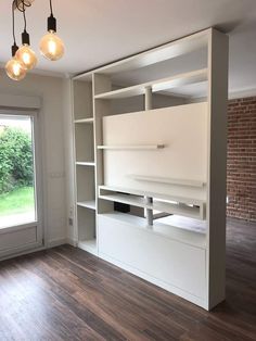 an empty room with some lights hanging from the ceiling and shelves in front of it