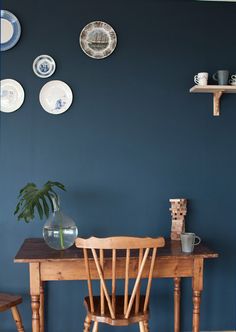 a dining room with blue walls and plates on the wall