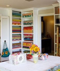 a room filled with lots of different types of fabrics and quilting material on shelves