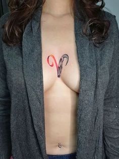 a woman's breast with an umbrella tattoo on her chest