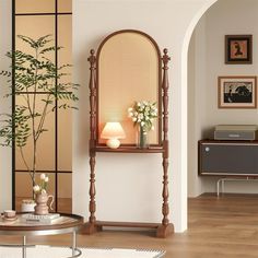 a living room filled with furniture and a tall mirror on top of a shelf next to a plant