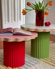 two colorful tables with books and flowers in vases