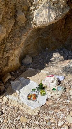 a picnic is set up on the ground near some rocks