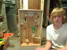 a young man sitting in front of a wooden box