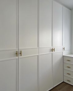 a room with white cabinets and drawers in it