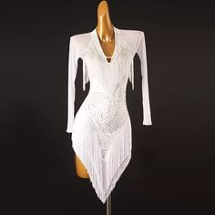 a mannequin wearing a white flap dress with fringes on the bottom and long sleeves