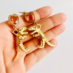 This one's a fan favorite! Handmade gold t-rex dinosaur skeleton earrings with a cute heart charm accent. Made for all you dinosaur nerds out there. Add some pizzaz to your outfit! ----- SPECIFICATIONS Handmade item / Made to Order Length: 3.5cm; Width: 1.5cm Materials: Brass, Stainless steel Closure: Ear wire (gold plated, hypo-allergenic for sensitive ears) Color: Gold, pink Style: Fun, Cute, Novelty, Whimsical ----- Thank you so much for supporting Flower Bunny - it means a lot to me! I hope you love your new one-of-a-kind goodies as much as I had fun making them and that they bring a little joy and magic to your day every time you see them! (: Fore more Flower Bunny products, check out my full Etsy store: https://www.etsy.com/shop/flowerbunnyshop Follow Flower Bunny on Instagram and Ti Skeleton Earrings, Dinosaur Skeleton, T Rex Dinosaur, Fun Cute, Rose Style, Pink Style, Handmade Gold, Earrings Dangle, T Rex