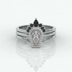 a white gold ring with black and white diamonds on the sides, set in 18k white gold