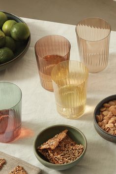 there are several bowls and glasses on the table with food in them, including crackers