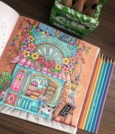 an open children's book on a table with colored pencils