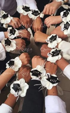 a group of people sitting around each other with flowers on their wrists and ties