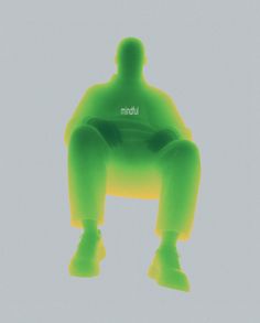 the silhouette of a man sitting on top of a green chair with his legs crossed