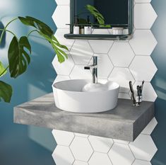 a bathroom sink sitting on top of a counter next to a potted green plant