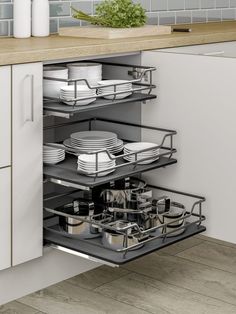 an open drawer in a kitchen filled with dishes