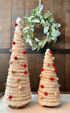 two small christmas trees sitting on top of a table