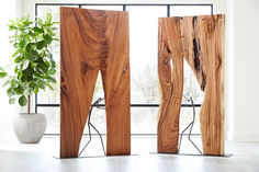 three pieces of wood sitting on top of a floor next to a potted plant