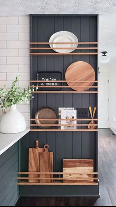 the shelves in this kitchen are organized with wooden cutting boards and other utensils