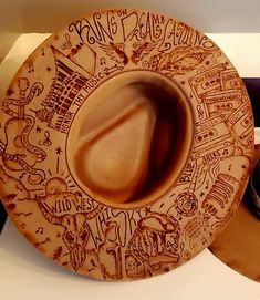 a brown plate with writing on it sitting on top of a counter next to other items