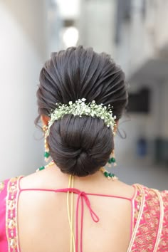 the back of a woman's head wearing a hair piece with flowers in it