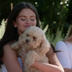 a woman holding a dog in her arms