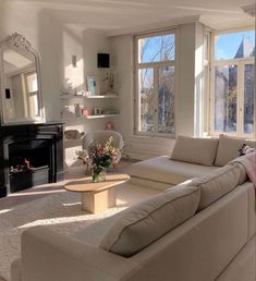 a living room filled with furniture and a fire place in front of a large window