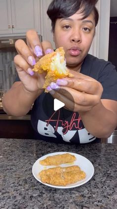 a woman eating food from a white plate on top of a counter