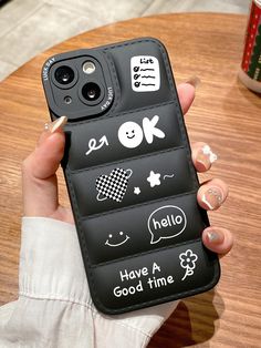 a person holding up a cell phone case with stickers on it