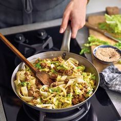 a person cooking food in a pan on the stove