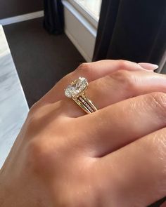 a woman's hand holding a diamond ring