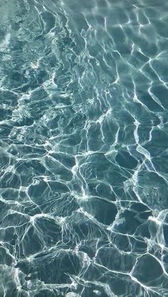 water ripples over the surface of a swimming pool, with sunlight reflecting on it