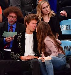 two people sitting next to each other at a basketball game