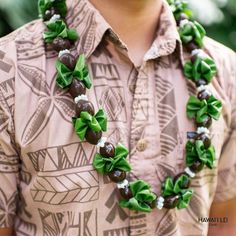 a close up of a person wearing a shirt with green and white flowers on it